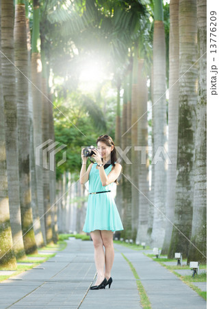One young Chinese woman taking picture with DSLR  13776209