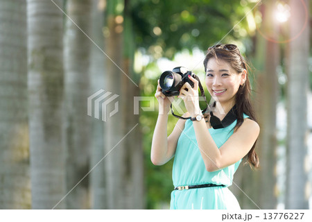 One young Chinese woman taking picture with DSLR One young Chinese woman taking picture with DSLR 13776227