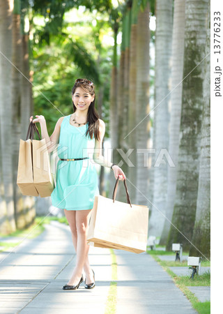 One young chinese woman shopaholic along promenade 13776233