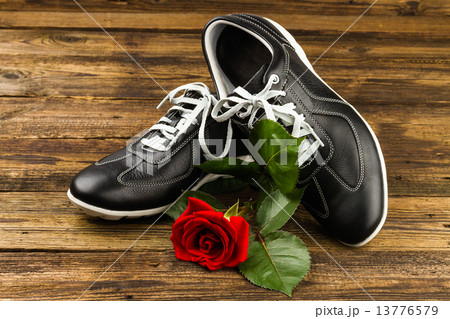 black man's shoes and rose 13776579