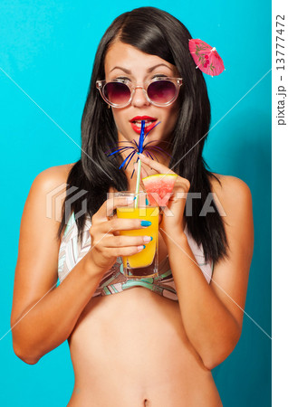 Beautiful girl in bikini with a cocktail in hand Beautiful girl in bikini with a cocktail in hand 13777472