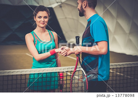 Woman tennis player shaking hand with her coach Woman tennis player shaking hand with her coach 13778098