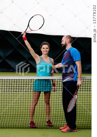 Woman player and her coach practicing on a tennis court Woman player and her coach practicing on a tennis court 13778102