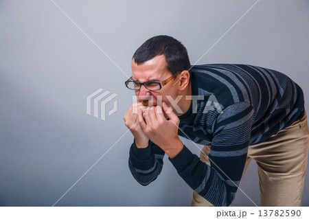 male of European appearance brunet put fingers in his mouth on a 13782590