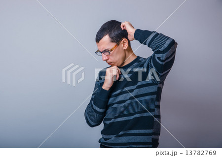 male of European appearance brunet thinking on a gray background male of European appearance brunet thinking on a gray background 13782769