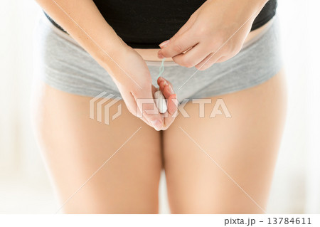 young woman in lingerie holding hygienic tampon 13784611