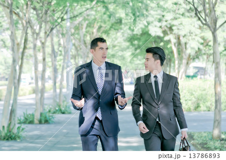 Two businessman walking and talking together 13786893