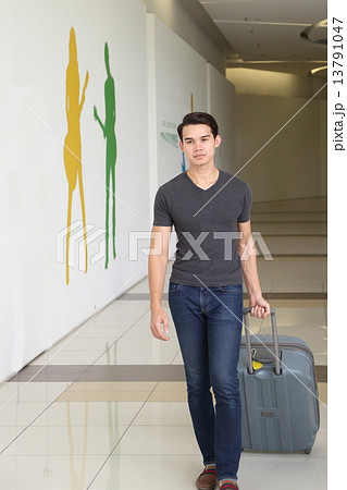 Asian young man walk forward with a luggage  Asian young man walk forward with a luggage  13791047