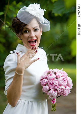 Happy bride laughing, covering mouth with her hand with bouquet of peony flowers. Happy bride laughing, covering mouth with her hand with bouquet of peony flowers. 13792481