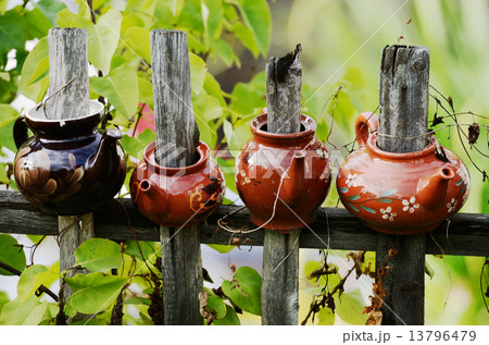 four ceramic teapot on a wooden fence 13796479