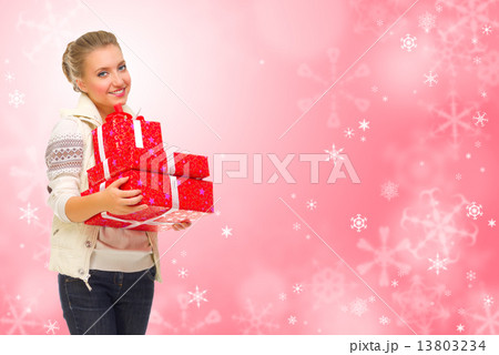 Young girl wth gift boxes on winter background 13803234