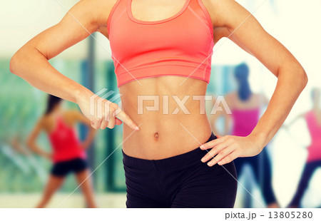 close up of woman pointing finger at her six pack close up of woman pointing finger at her six pack 13805280