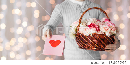 man holding basket full of flowers and postcard 13805292