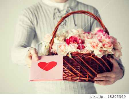 man holding basket full of flowers and postcard man holding basket full of flowers and postcard 13805369