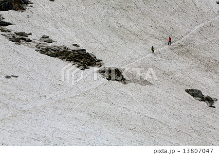 剱沢の雪渓を行く登山者 13807047