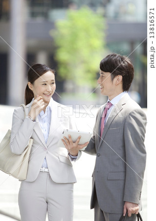 話をしているビジネスマンとビジネスウーマン 話をしているビジネスマンとビジネスウーマン 13816571