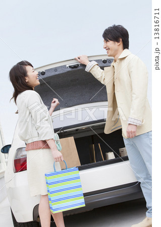 トランクの前で会話する夫婦 13816711