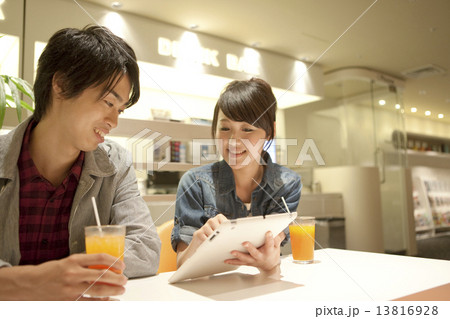 タブレットPCを見て話すカップル 13816928