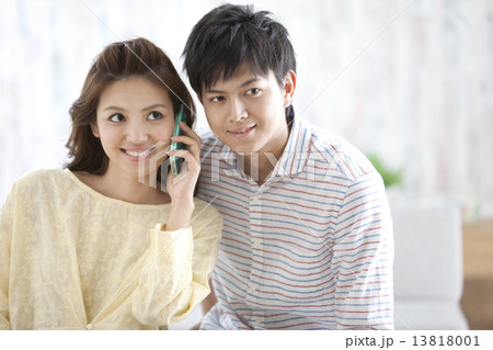 スマートフォンで電話するカップル 13818001