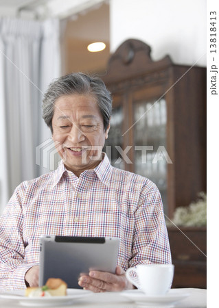 タブレットPCを操作する中高年男性 13818413