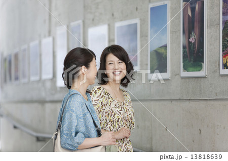 写真の前で話す中高年女性2人 13818639