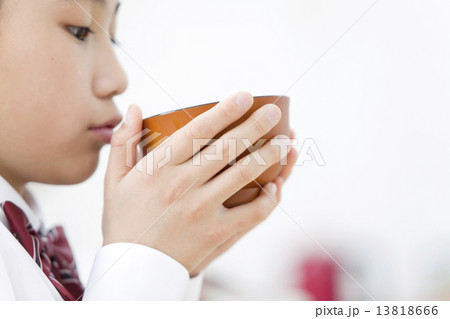 味噌汁を飲む女の子の写真素材