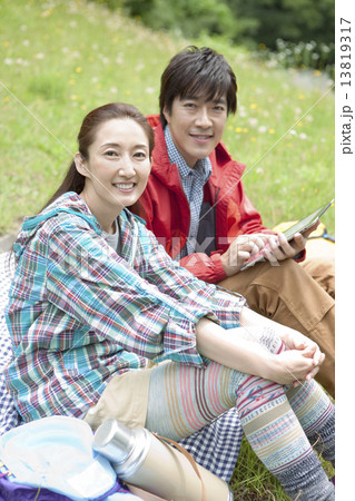 芝生に座る中高年夫婦 13819317