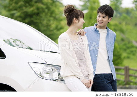 車の前に立つカップル 13819550