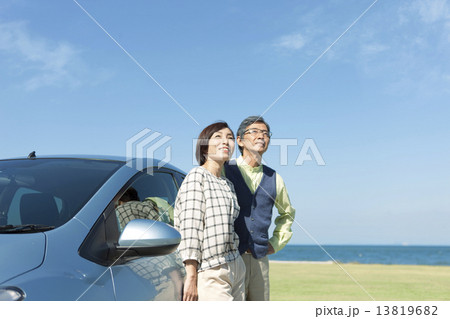 車にもたれる中高年夫婦 13819682