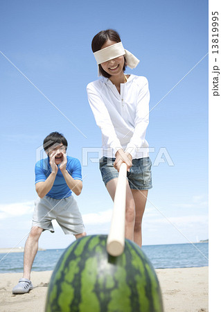 スイカ割りをするカップル 13819995