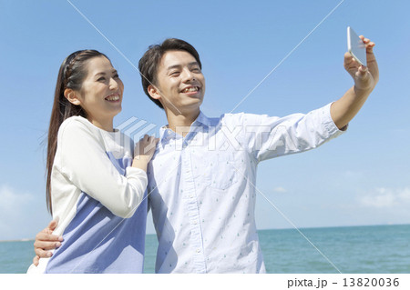 携帯電話で写真を撮るカップル 13820036