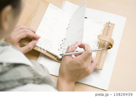 手帳を見る女性 13820439