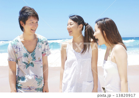 海辺で話をする若者3人 13820917