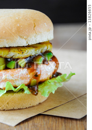 Homemade fish burger with salmon, avocado and pineapple.Close up 13826655