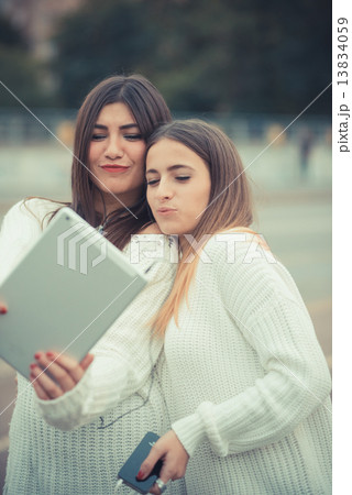 young couple beautiful women girls autumn using tablet 13834059