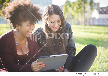 two multiethnic beautiful young woman black and caucasian using two multiethnic beautiful young woman black and caucasian using 13834886