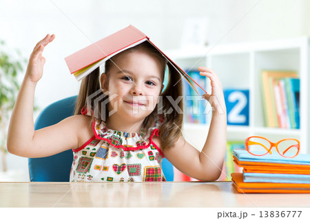 preschooler  kid girl with book over her head 13836777