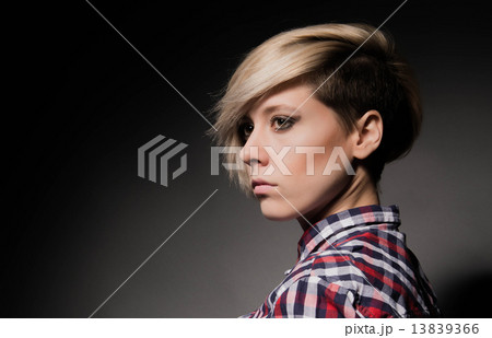 Blonde girl with a short stylish haircut on a dark background 13839366