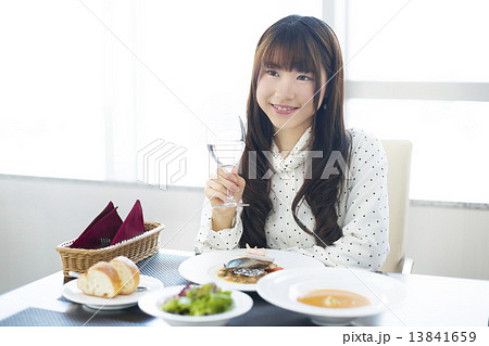 フレンチレストランで食事を楽しむ若い女性 13841659