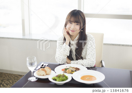 フレンチレストランで食事を楽しむ若い女性 13841676