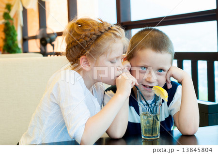Boy and girl drinking a drink with ice through a straw 13845804
