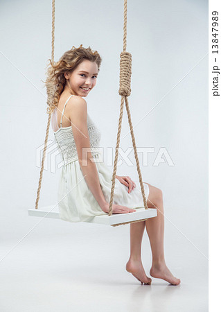 Beautiful smiling woman sitting on swing isolated Beautiful smiling woman sitting on swing isolated 13847989