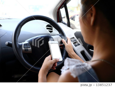 woman using a smart phone in car woman using a smart phone in car 13851237