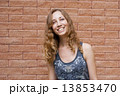 Photo of blonde girl with bright sincere smile on red brick back 13853470