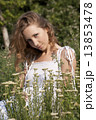 Photo of young blonde woman sitting near achillea bushes 13853478