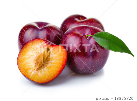 Ripe purple plum fruits with green leaves isolated on white 13855720