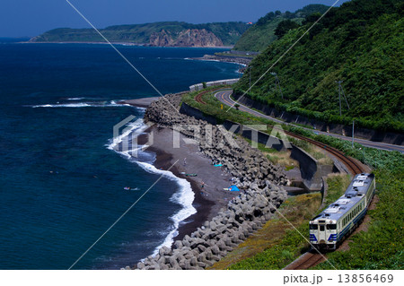 日本海の海岸線沿いを走る五能線のローカル列車 13856469