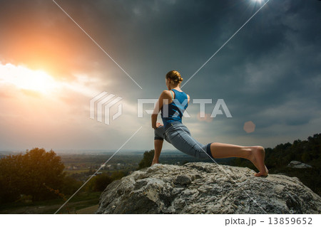 Woman doing yoga against the setting sun 13859652