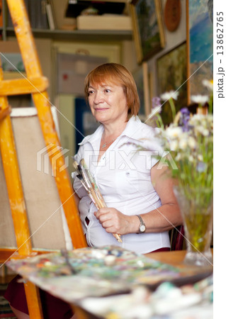 Female artist paints a picture on canvas 13862765