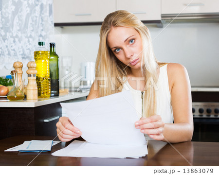 serious girl reading document at home 13863079